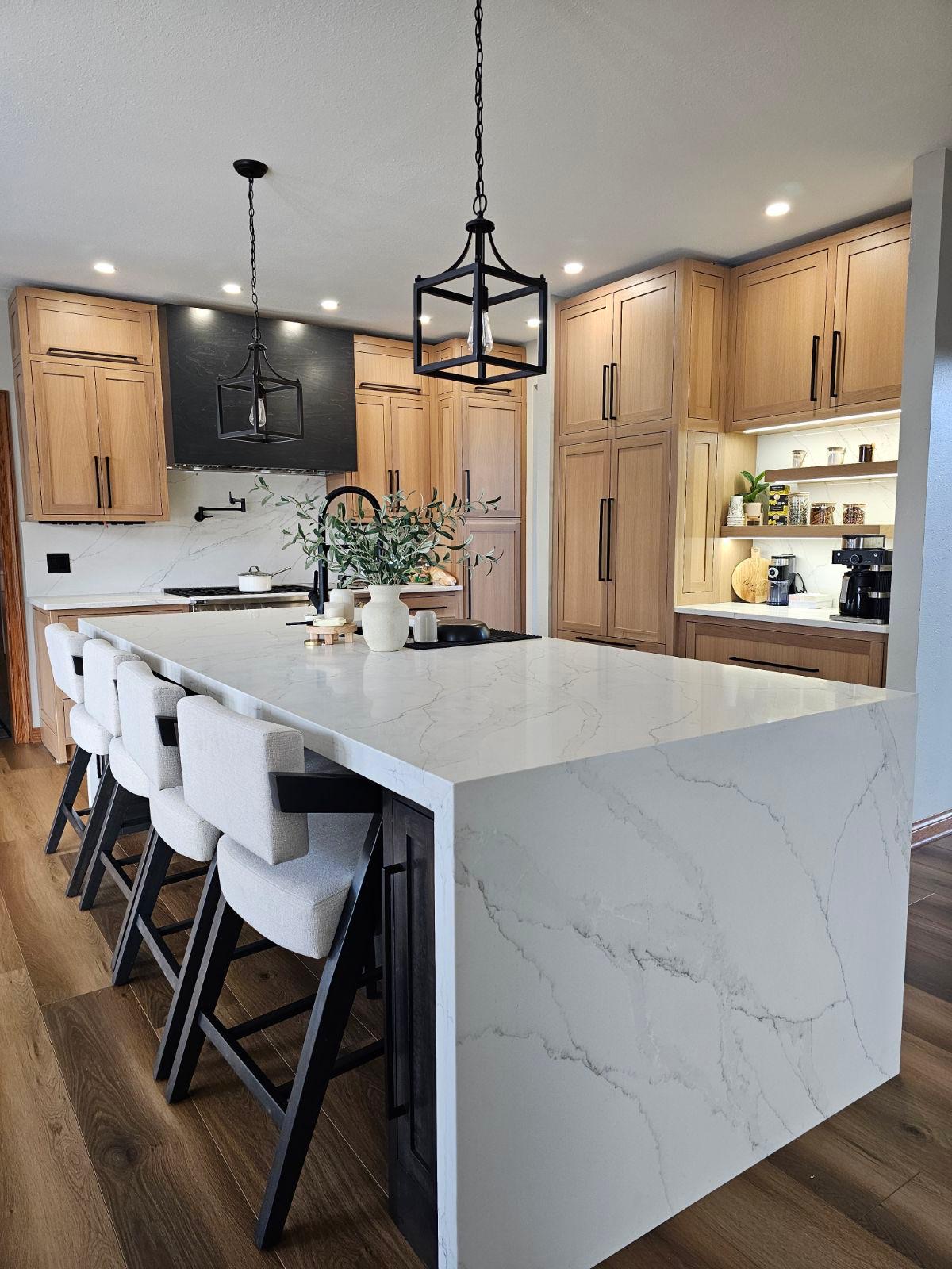 Natural oak kitchen with waterfall marble island by AT Cabinetry