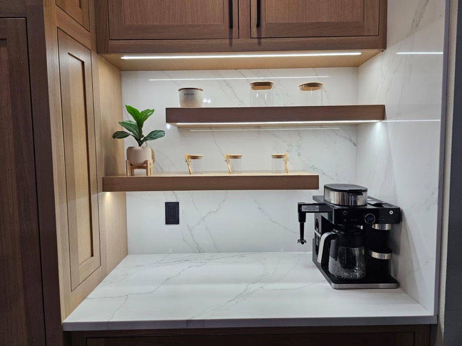 Built-in walnut butler’s pantry with floating shelves, glass canisters, a marble backsplash, and a coffee maker