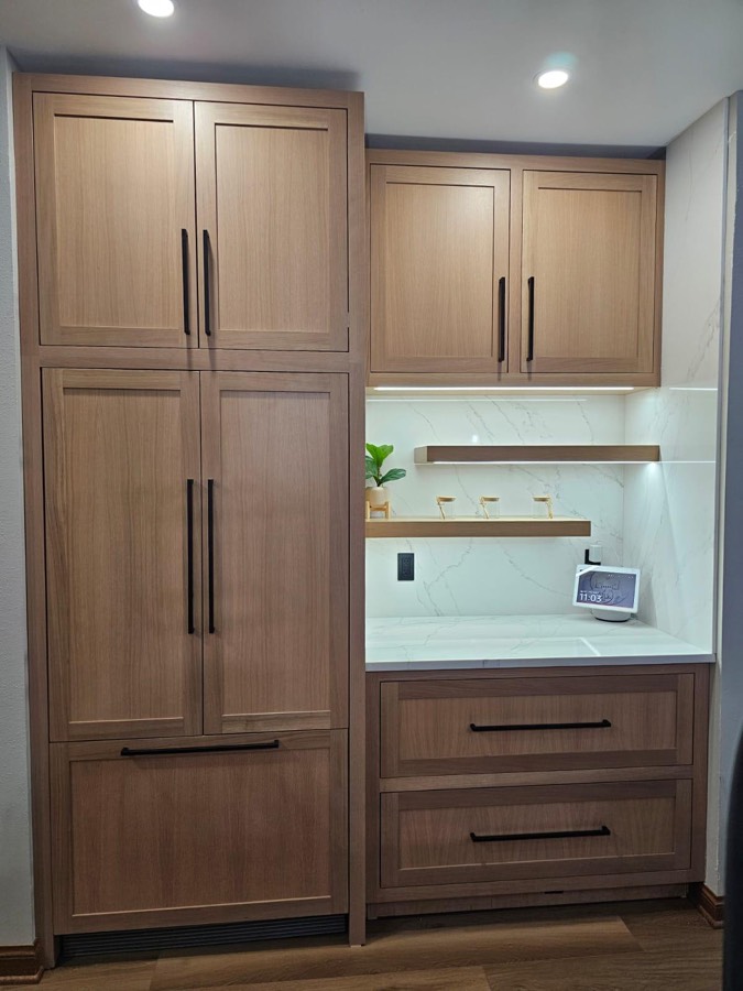 Built-in pantry wall with a paneled refrigerator, floating wood shelves, and a small appliance counter