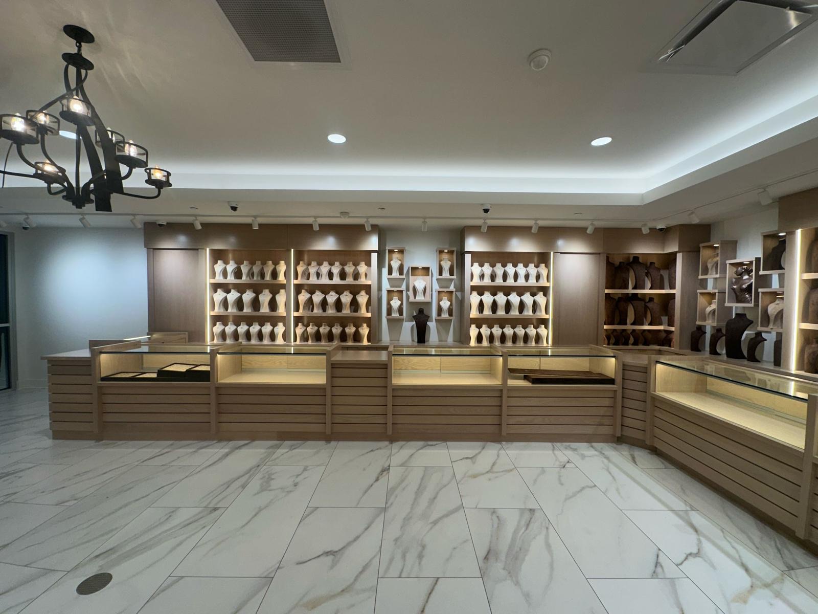 Custom oak jewelry showroom casework with backlit display shelving by AT Cabinetry